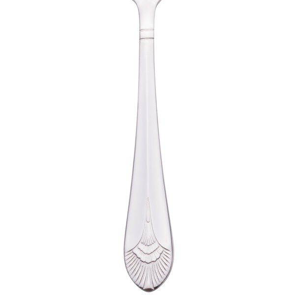 A close up of a Walco stainless steel teaspoon with a design on the handle.