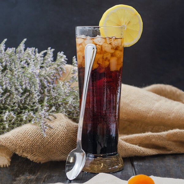 A glass of iced tea with a lemon slice and a Walco Lisbon stainless steel iced tea spoon.