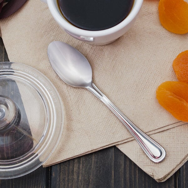 A Walco Lisbon demitasse spoon in a cup of coffee on a saucer.