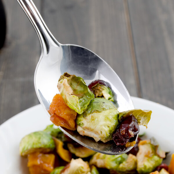 A Walco stainless steel tablespoon full of food on a plate.