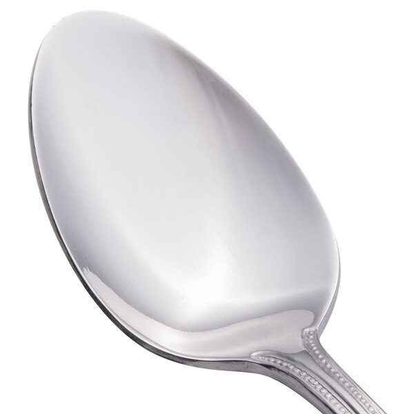 A close-up of a Walco stainless steel serving spoon with a handle.