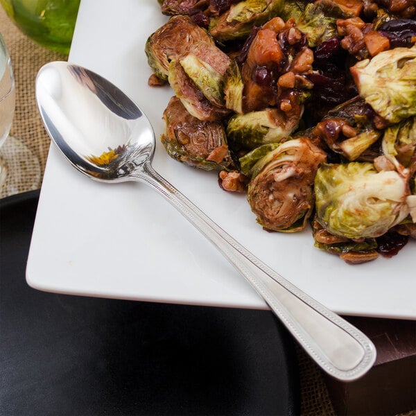 A plate of food with a Walco stainless steel tablespoon on it.