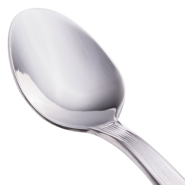 A close-up of a Walco Bosa Nova stainless steel demitasse spoon with a white handle.