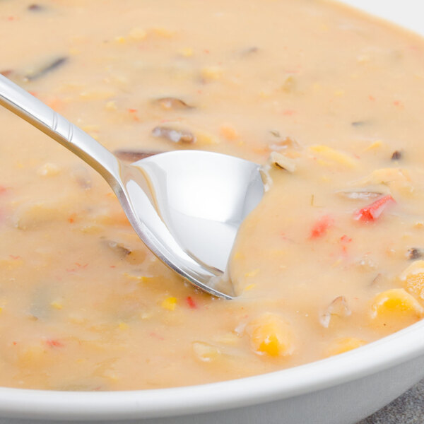 A Walco Meteor stainless steel bouillon spoon in a bowl of soup.