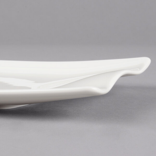 A white Villeroy & Boch rectangular platter with a curved edge on a gray surface.