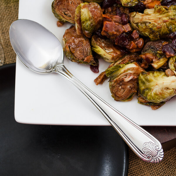 A plate of food with a Walco Danish Pride serving spoon next to it.