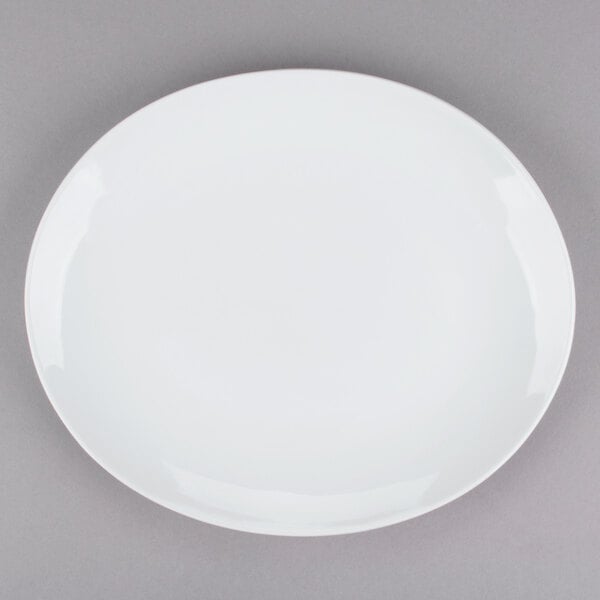 A Tuxton bright white china platter with a white rim on a gray surface.