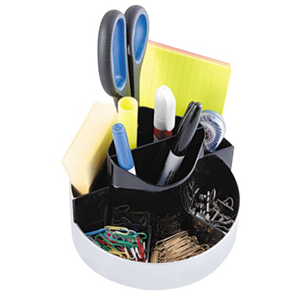 A black and white circular desk organizer with stationery items including pens and paper clips.