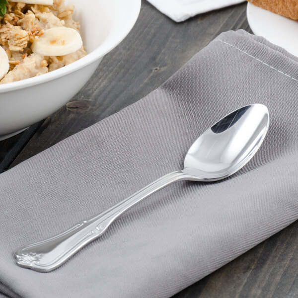 A Walco Barony stainless steel teaspoon on a napkin next to a bowl of oatmeal with bananas.