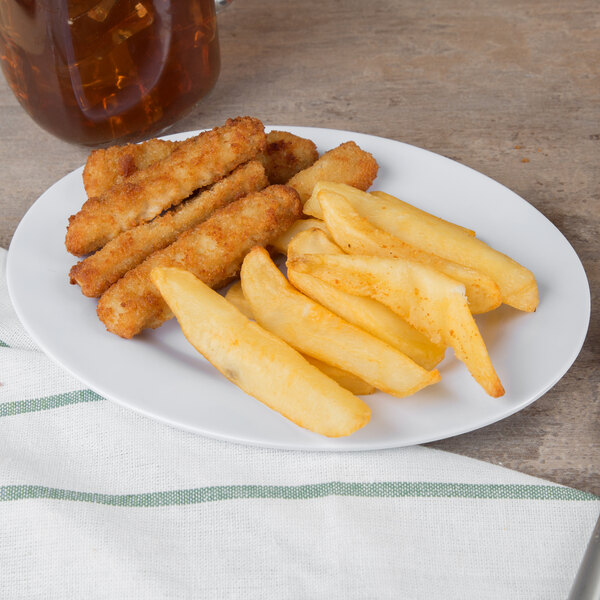 A white oval melamine platter with fried food on a table.