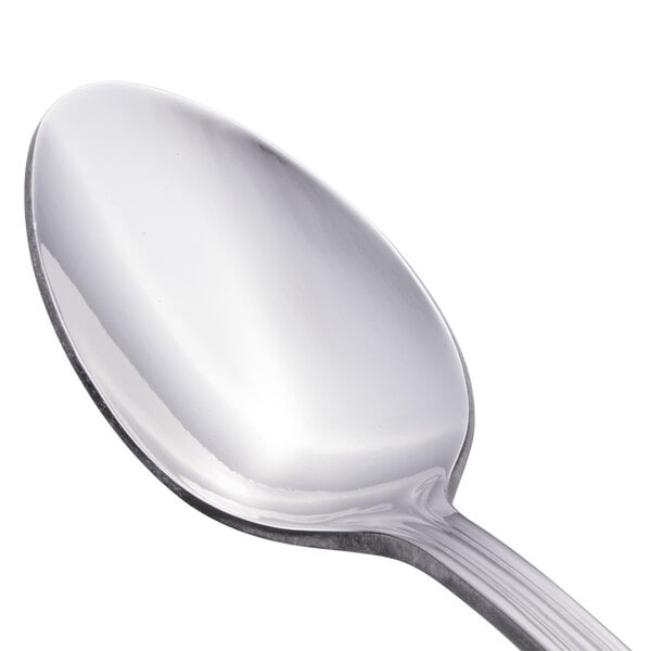 A close-up of a Walco stainless steel teaspoon with a silver handle.
