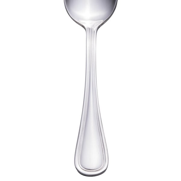 A close-up of a Walco stainless steel teaspoon with a silver handle.
