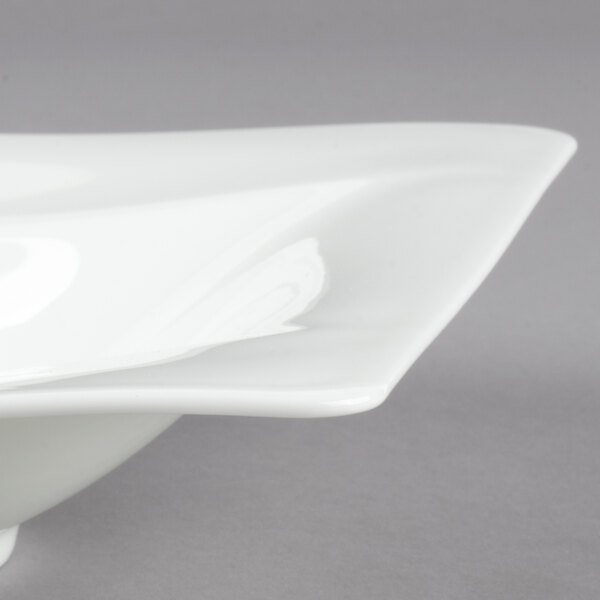 A close-up of a Villeroy & Boch Modern Grace white bone porcelain deep plate with a curved edge.