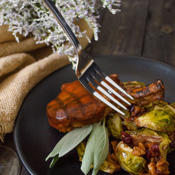 A Walco Marcie stainless steel table fork on a plate of food.