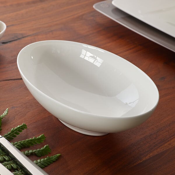 A Villeroy & Boch white bone porcelain bowl on a wood table.
