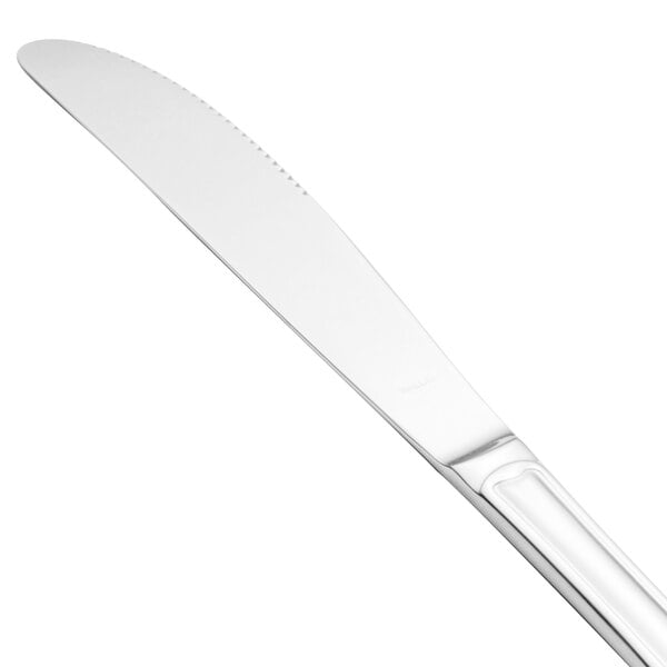 A Walco stainless steel table knife with a white handle and silver blade.