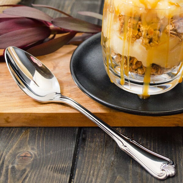 A Walco Barony stainless steel dessert spoon next to a dessert in a glass.