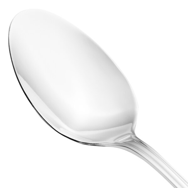 A close-up of a Walco stainless steel serving spoon with a white handle.