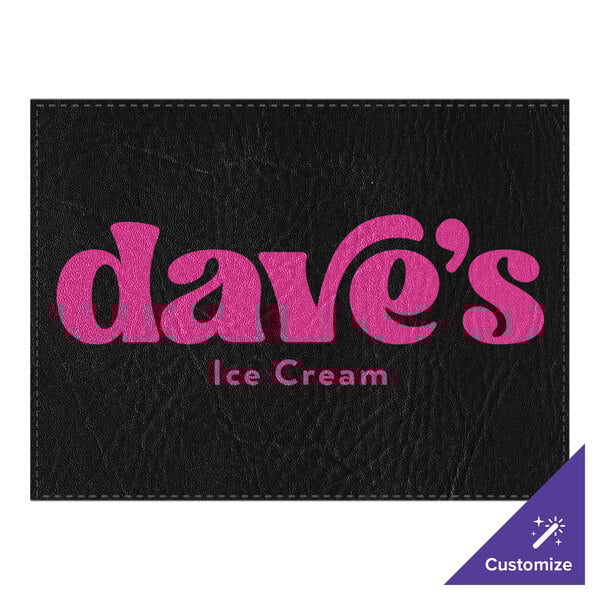 A black faux leather rectangular placemat with pink custom text.