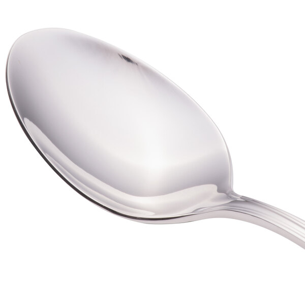 A close-up of a Walco stainless steel spoon with a silver handle.