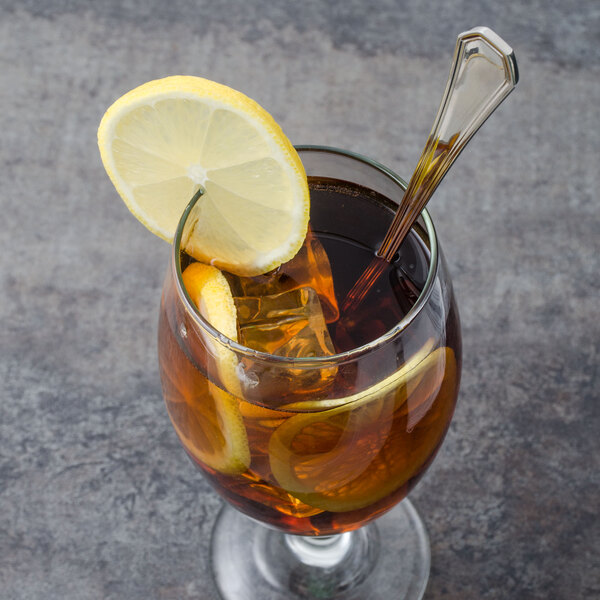 A Walco stainless steel iced tea spoon in a glass of iced tea with a lemon slice.
