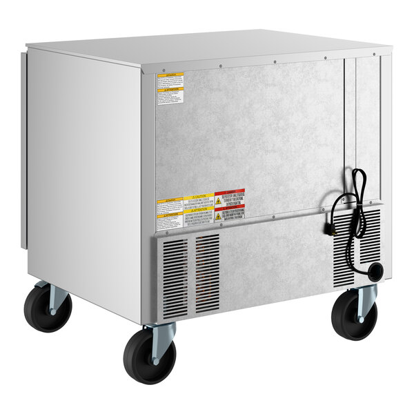 A stainless steel undercounter refrigerator on wheels with a power cord and ventilation grates.