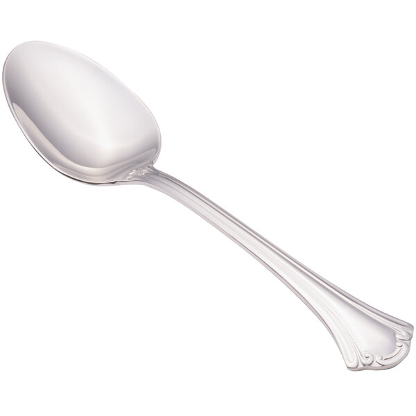 A close-up of a Walco stainless steel serving spoon with a handle.