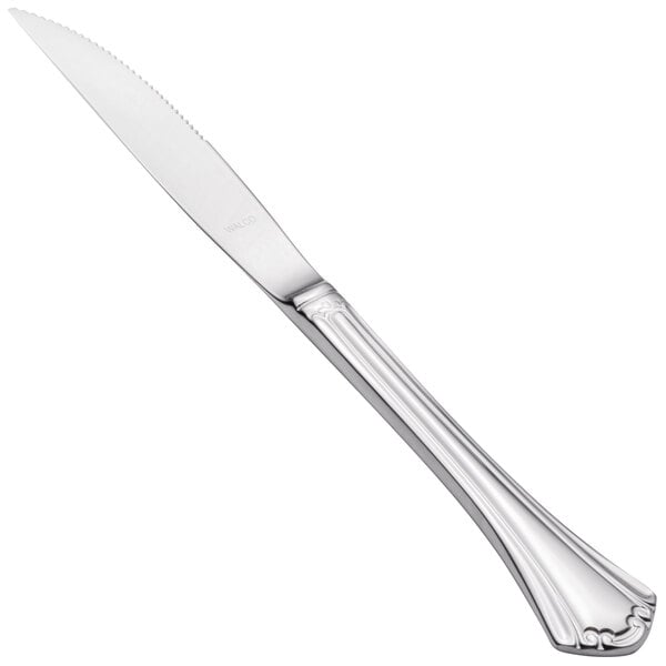 A close-up of a Walco stainless steel steak knife with a solid handle.