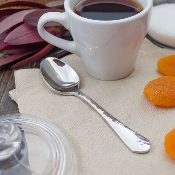 A Walco stainless steel demitasse spoon in a cup of coffee on a table.