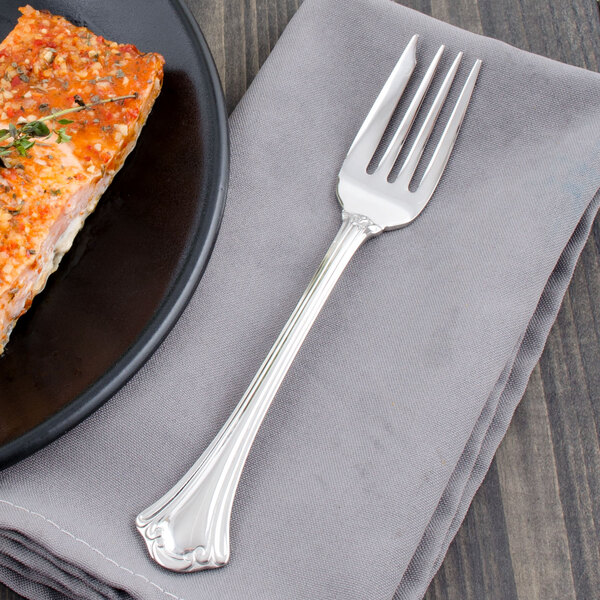 A Walco stainless steel fish fork on a plate of food.