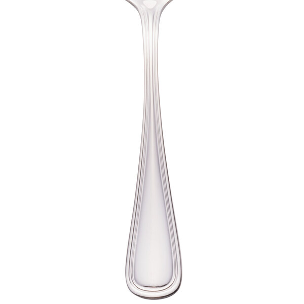 A close-up of a Walco stainless steel dessert spoon with a white background.