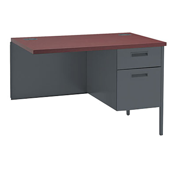 A mahogany desk with a right return and drawers on a charcoal top.