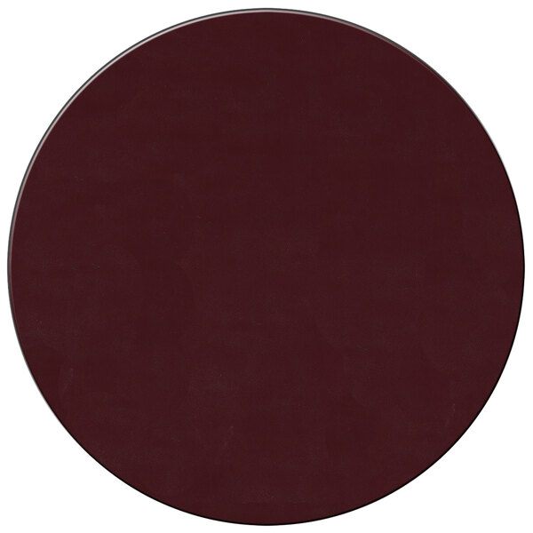 A dark red round vinyl placemat with white dots on a table.