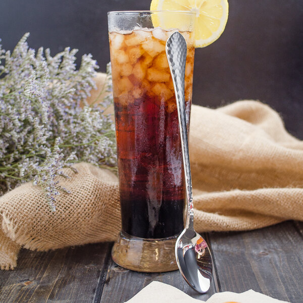 A glass of iced tea with a lemon slice and a Walco stainless steel iced tea spoon.