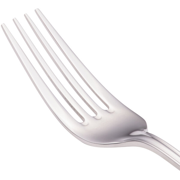 A close-up of a Walco European table fork with three silver forks in the background.