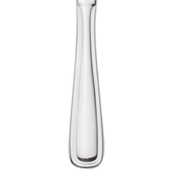 A Walco stainless steel steak knife with a white handle and black band.