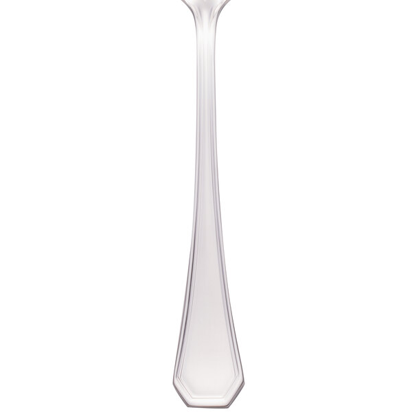 A close up of a Walco stainless steel serving spoon with a white background.