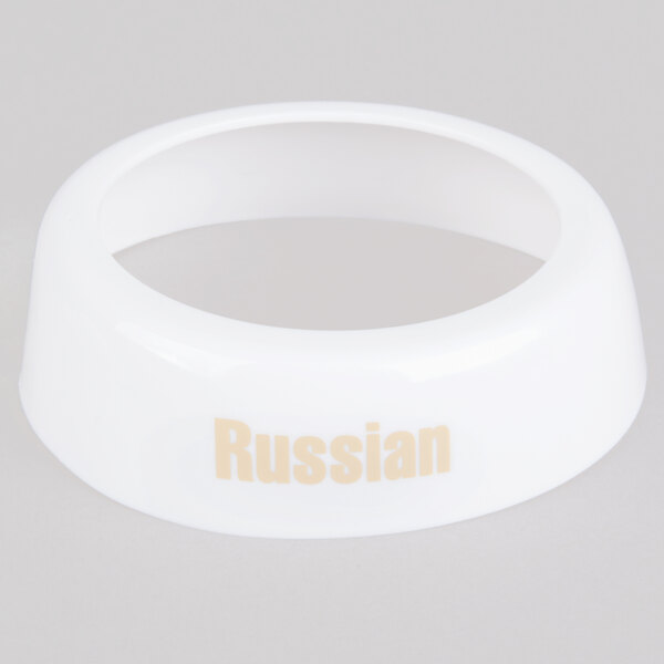 A white plastic Tablecraft collar with beige lettering that says "Russian"