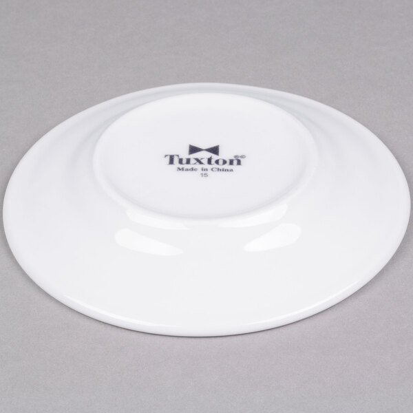 A bright white Tuxton Alaska china plate with black text that reads "Alaska"