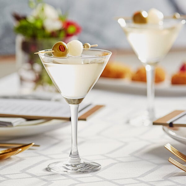 Cocktail in a miniature martini glass topped with an olive and an onion