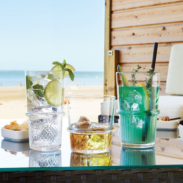 Arcoroc rocks glasses filled with drinks on a table.