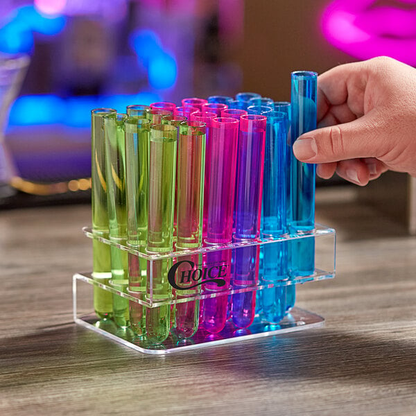 A hand holding a blue test tube from a rack of colorful test tubes.