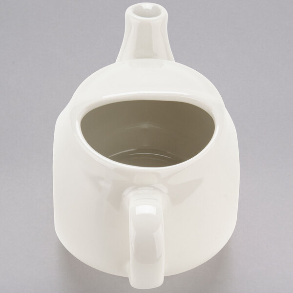 a white teapot with a handle