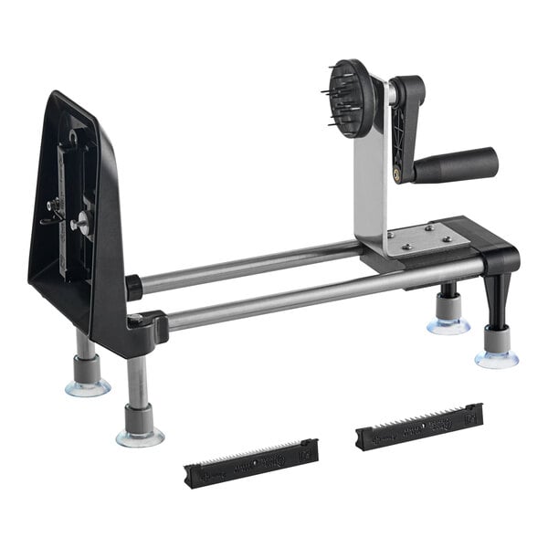 A black and silver Bron Coucke Le Rouet manual spiral vegetable slicer on a table with metal legs.