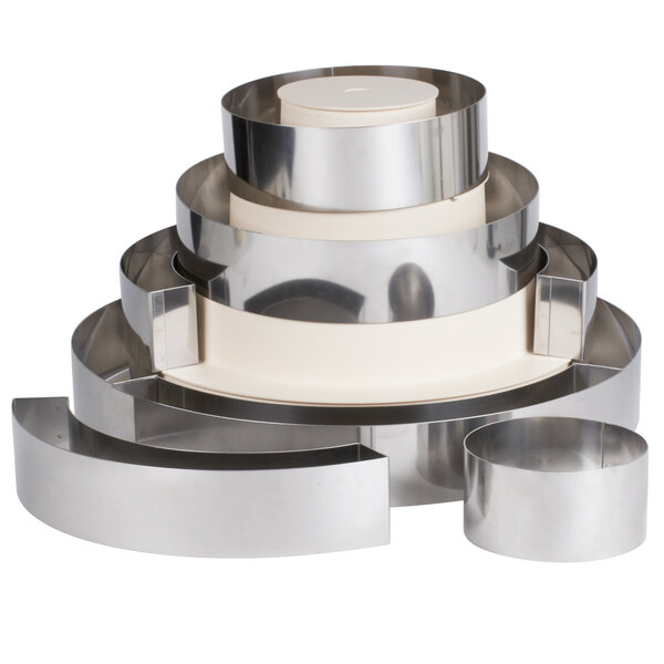 A stack of Matfer Bourgeat stainless steel round wedding cake ring frames.