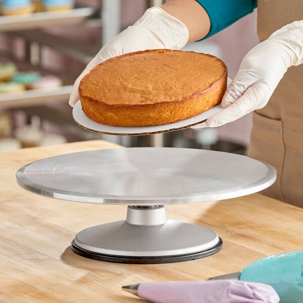 A 12-inch revolving cake stand made of metal, designed for decorating cakes.