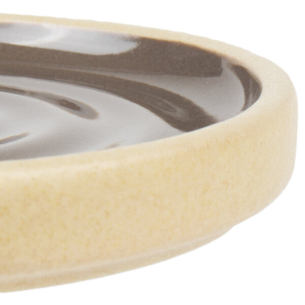 A close-up of a gray Chef & Sommelier stackable plate with a wavy rim.