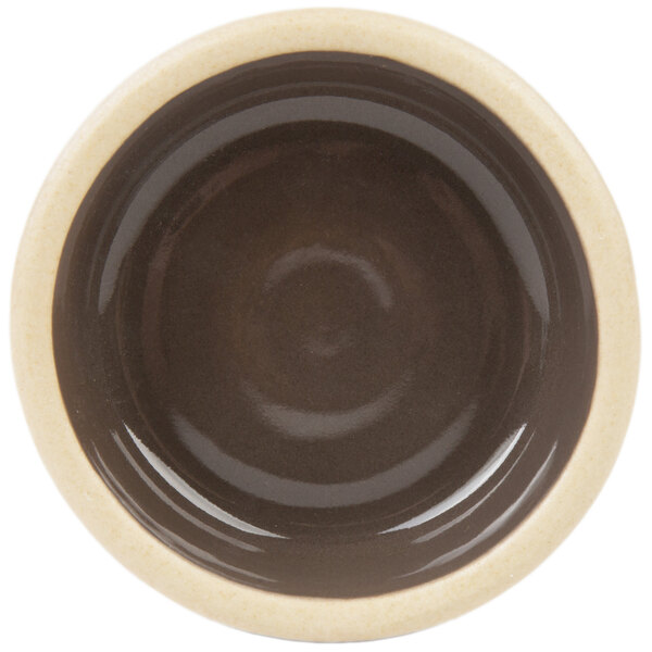 A brown and white stackable stoneware ramekin with a circular pattern in the middle.