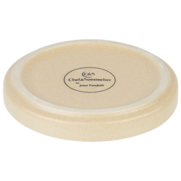 A white stoneware plate with a circular design on it.