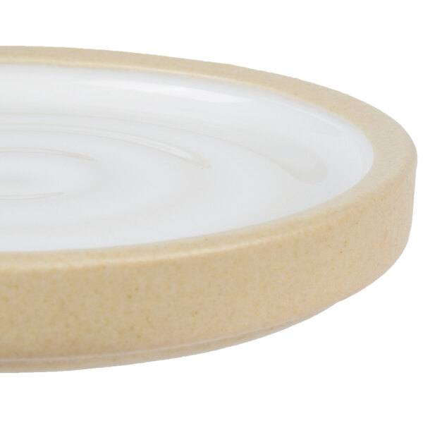 A close up of a Chef & Sommelier white ceramic stoneware plate with a circular rim.